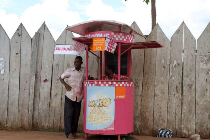 Men wait for customers in a kiosk for phone cards recharge, along a street in the Cameroonian capital Yaounde